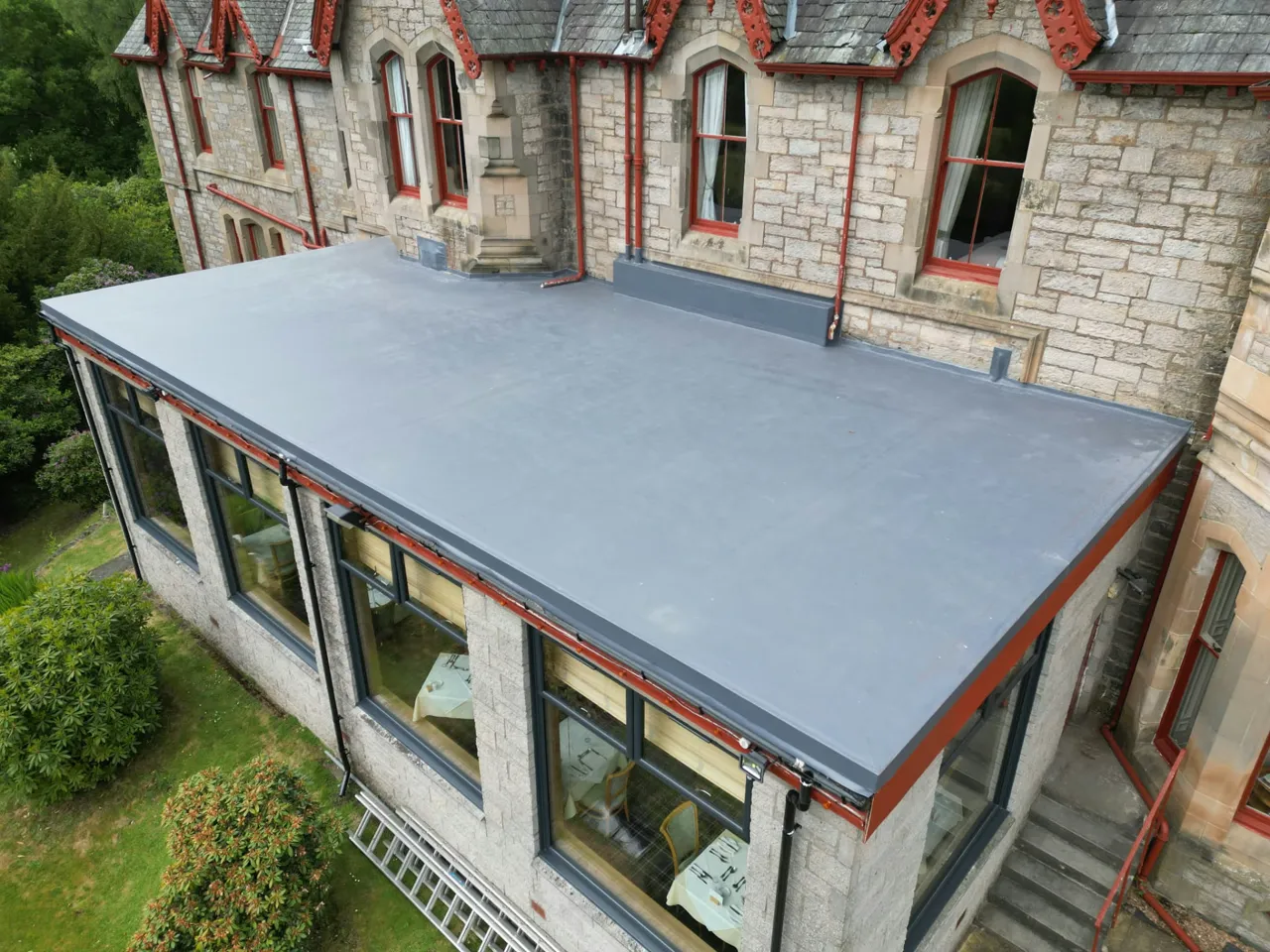 New grey single-ply flat roof on a stone building extension in Perthshire