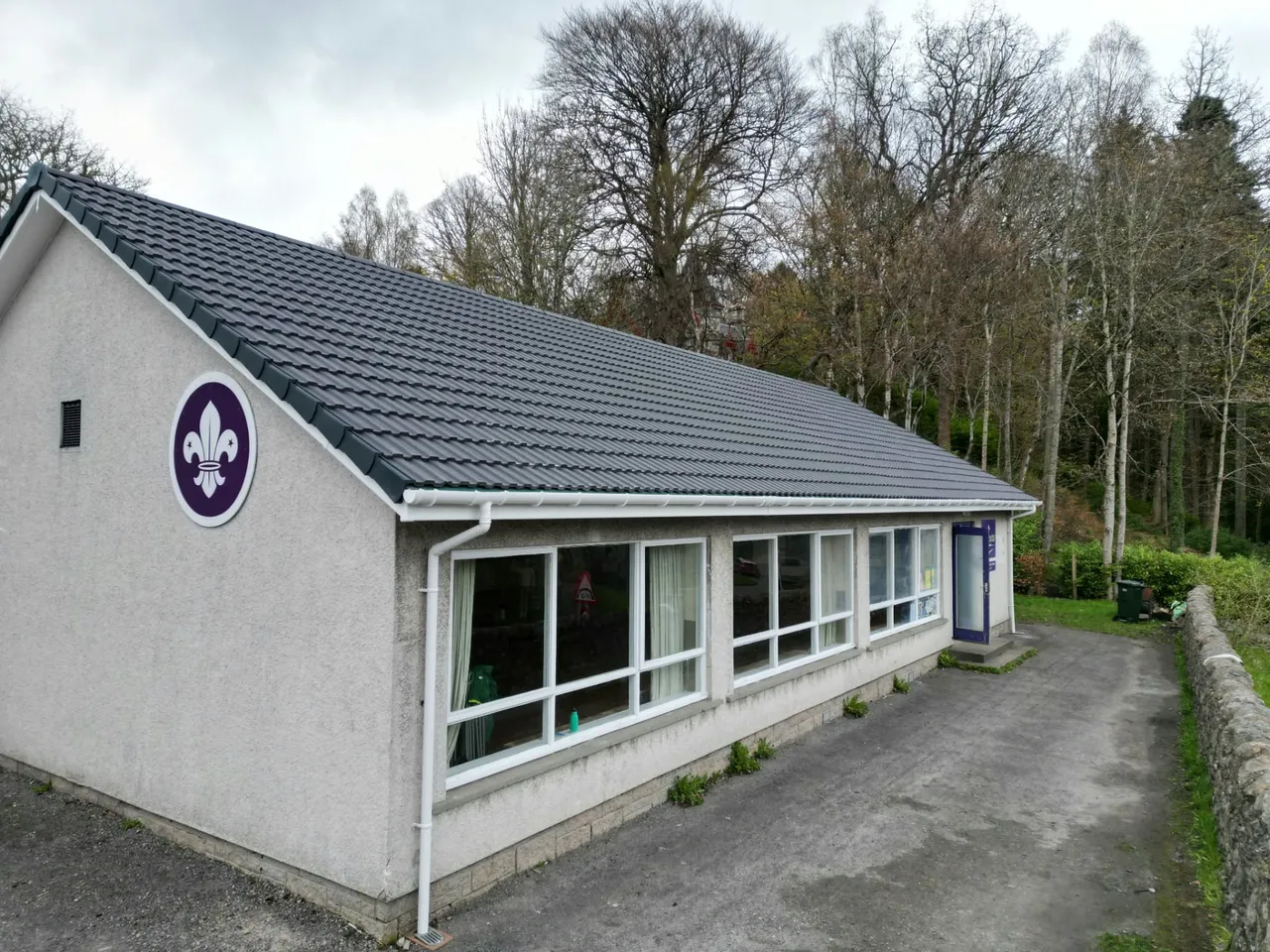 Scout hall with a new grey tiled roof and new white guttering