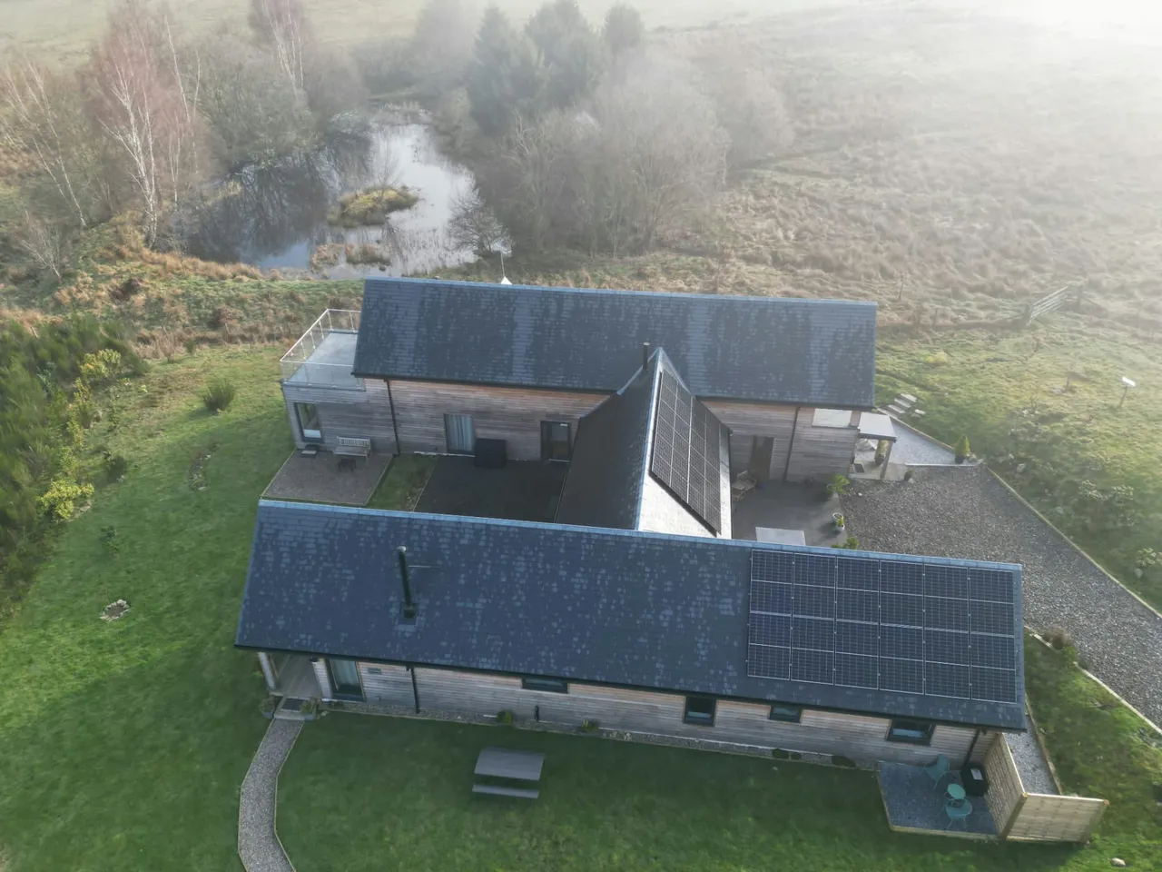 Top-down view of slate roofs and solar panels on a courtyard house