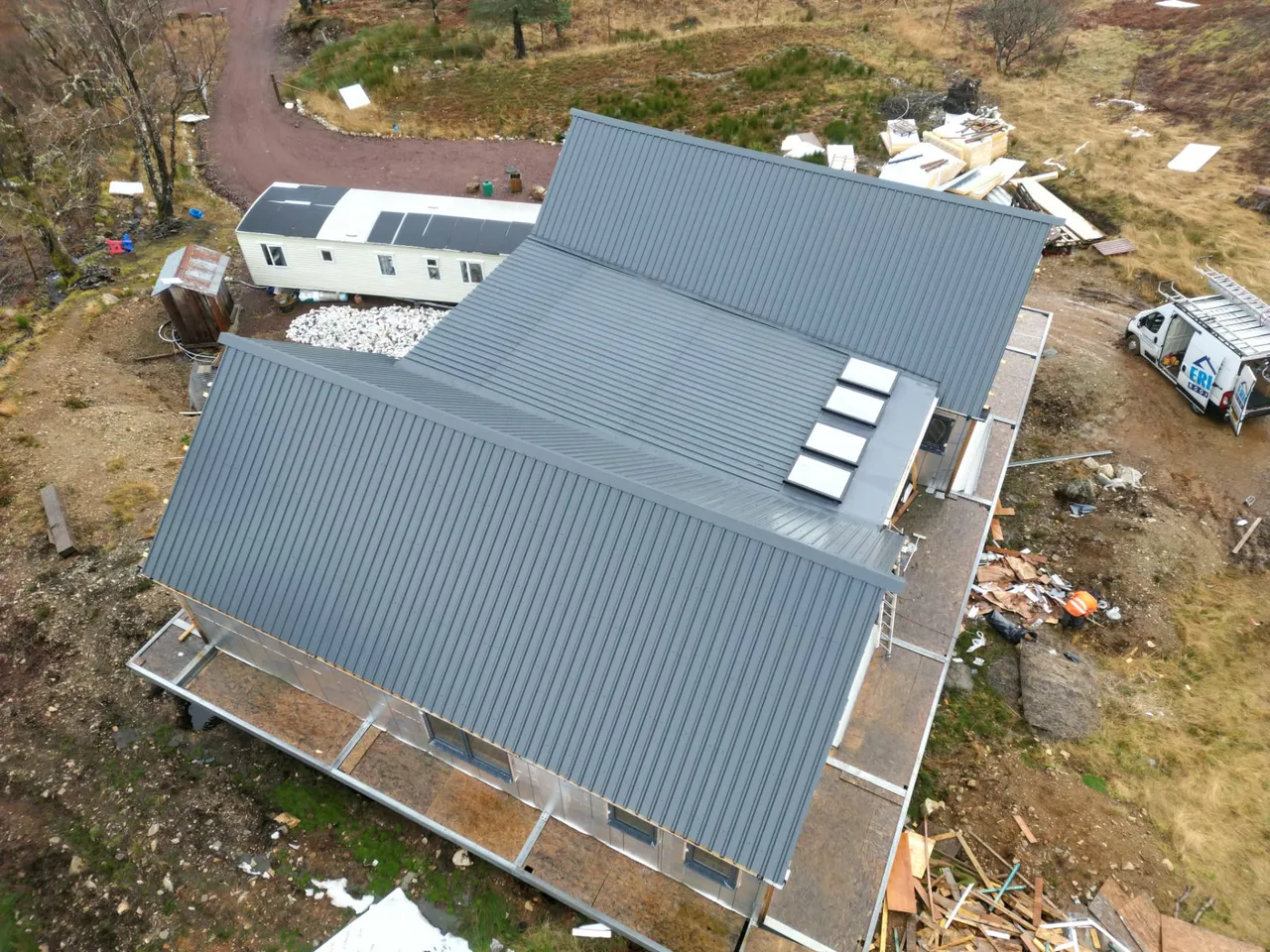 Overhead view of new metal roofing and rooflights on a new-build house with the Ericht Roofing van on site